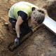 NTNU archaeologist Astrid Kviseth pulling the sword from the grave.
